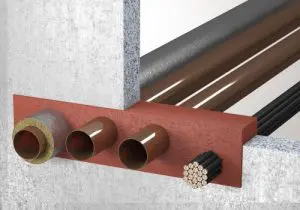 Three pipes and a cable pass through a fire-resistant barrier in a concrete wall, protected by UL firestop systems for enhanced safety.