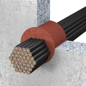 A bundle of insulated wires passes through a wall with a red sealing material around the opening.