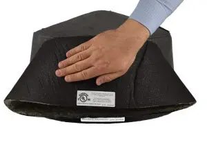 A hand presses down on black insulation with a UL certification label attached, ensuring it’s safe to use with recessed light covers.
