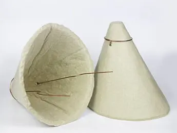Two conical beige lampshades with exposed wire frames, one upright and one lying on its side.