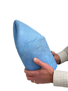 A person holding a folded blue towel with both hands, wearing a checked long-sleeve shirt.