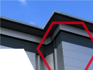Corner of a modern building with a red geometric outline against a blue sky.