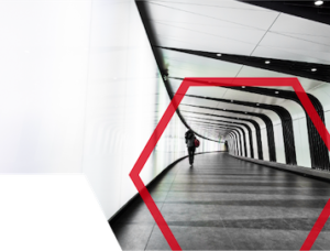 Person walking through a modern, tunnel-like hallway with geometric red shape overlay.