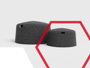 Two black, speckled, dome-shaped objects with small rectangular holes and a red hexagonal outline.