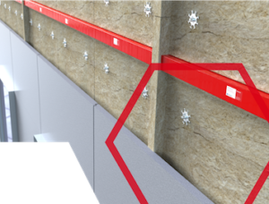 Close-up of a building wall showing insulation, red brackets, and panel attachments in a construction detail.