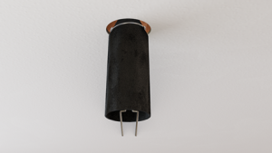 A black cylindrical fire rated ceiling recessed light fixture with two metal prongs visible at the bottom.