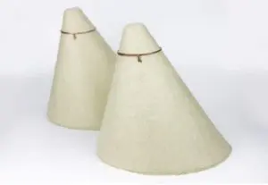 Two beige, cone-shaped felt hats, resembling recessed light insulation covers, each with a small string or band near the top, on a white background.