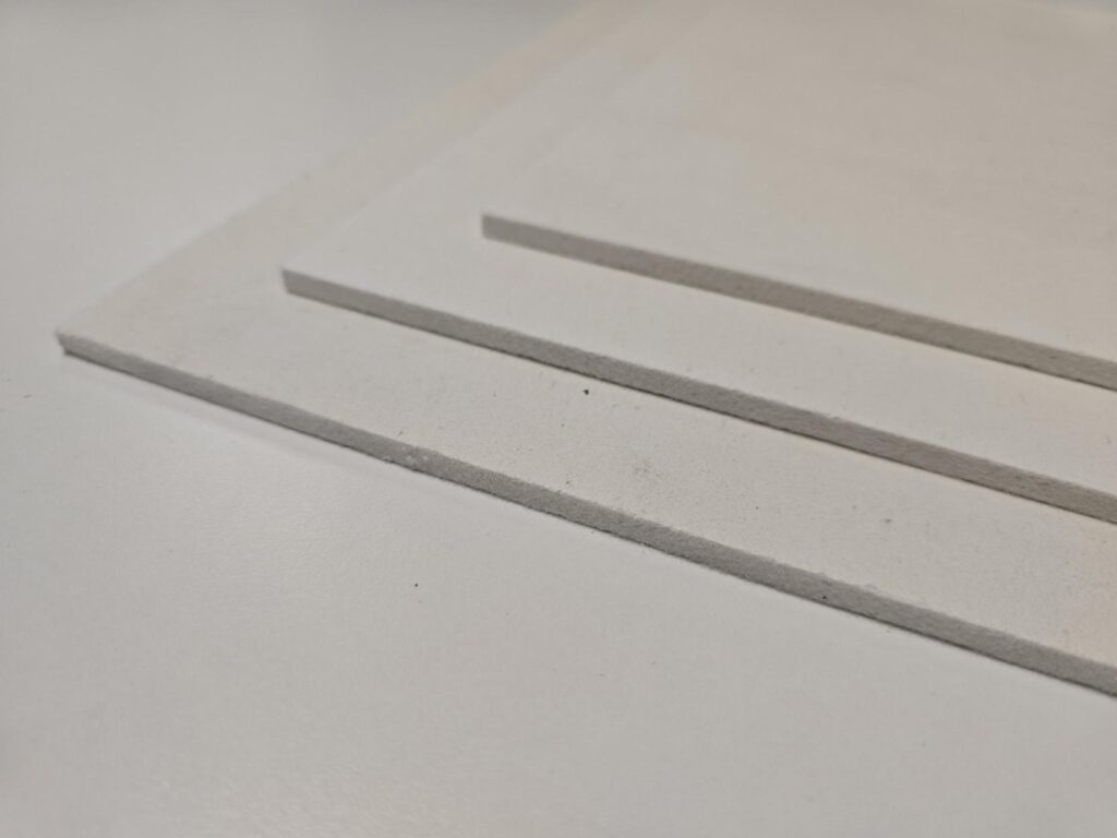 Three white rectangular sheets stacked on a light surface.